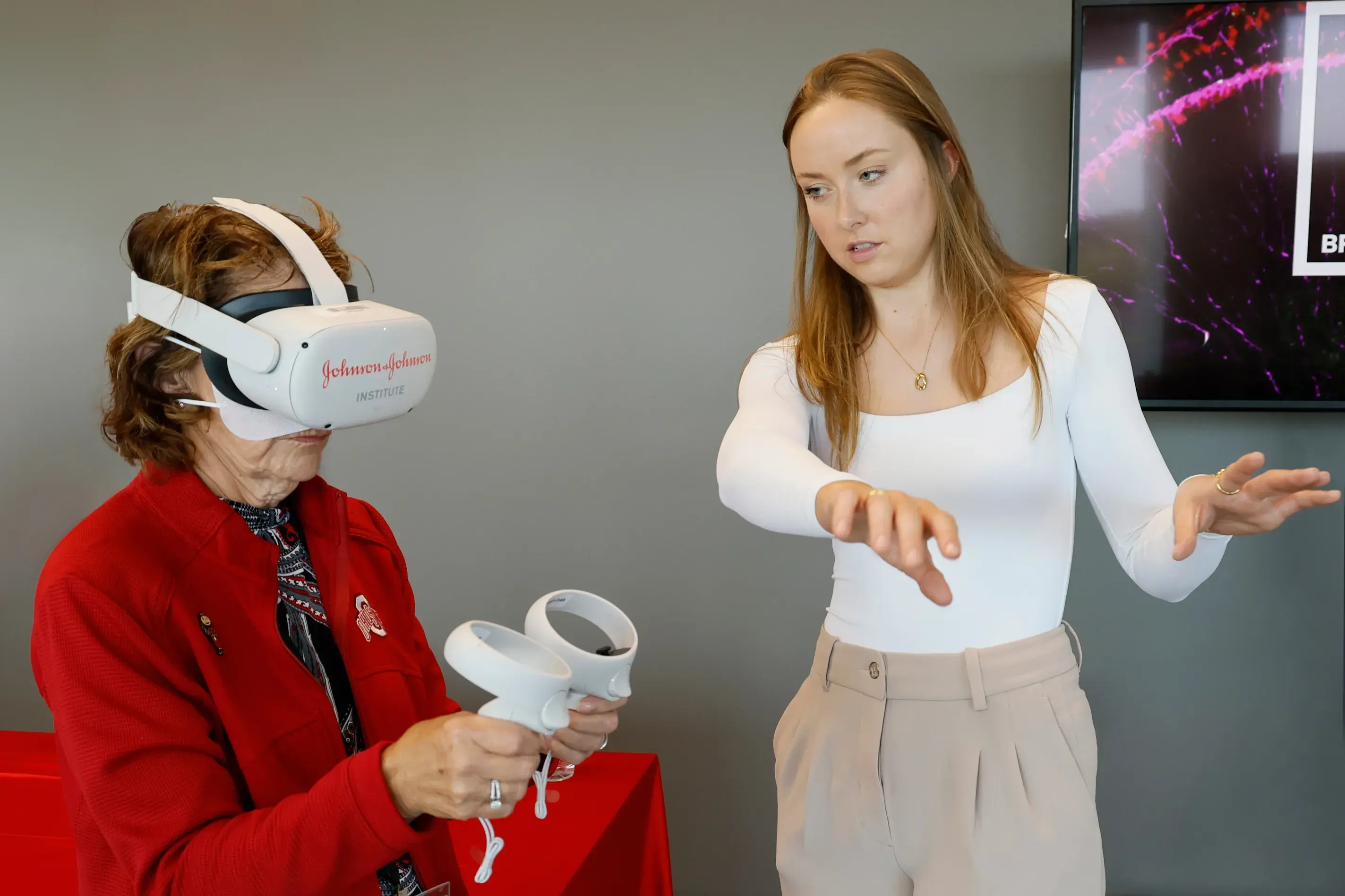 young woman training a female ohio state employee how to use an augmented reality headset